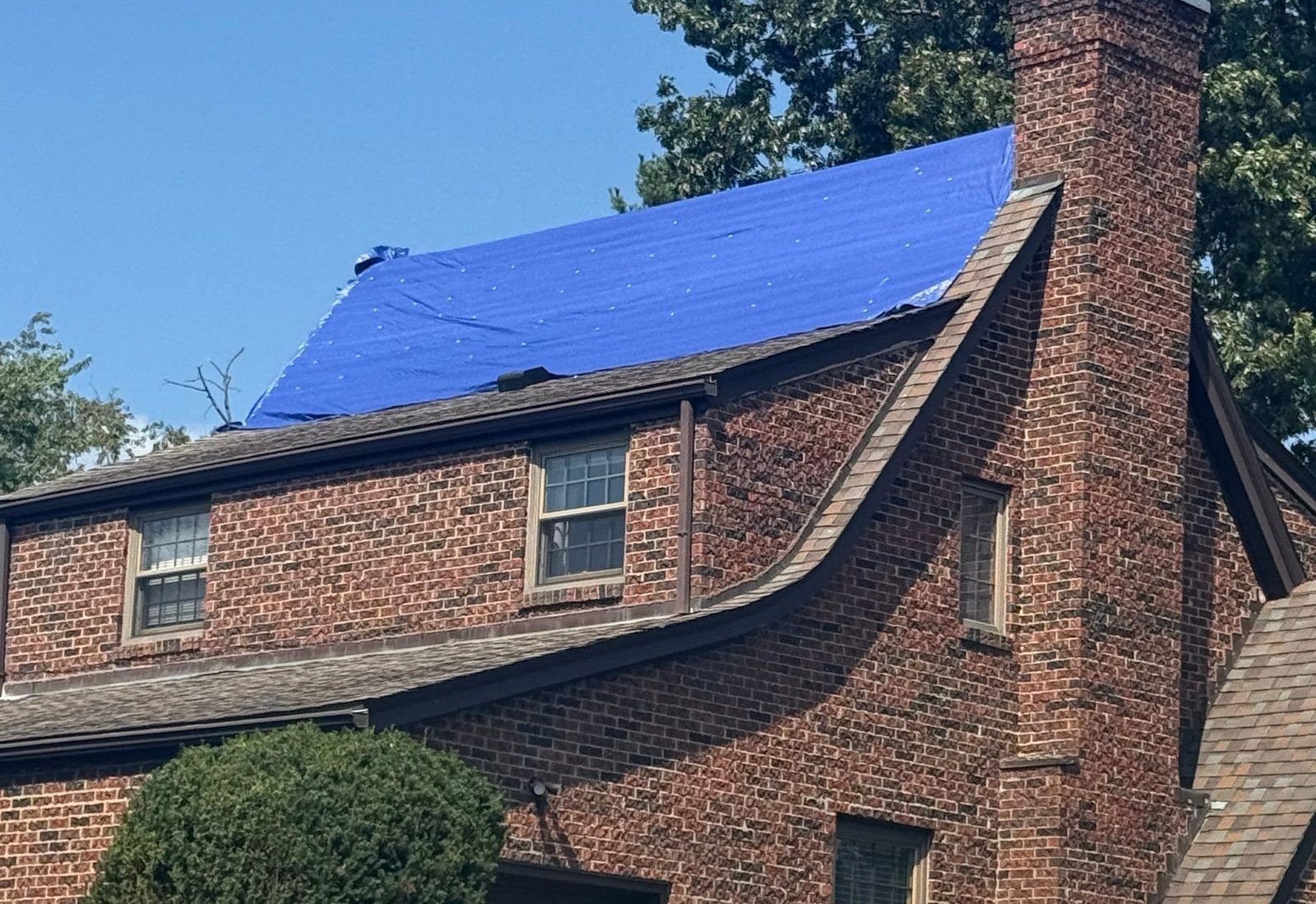 Brick home in South Hills, Pittsburgh, PA, with a tarp over the old roof before replacement.